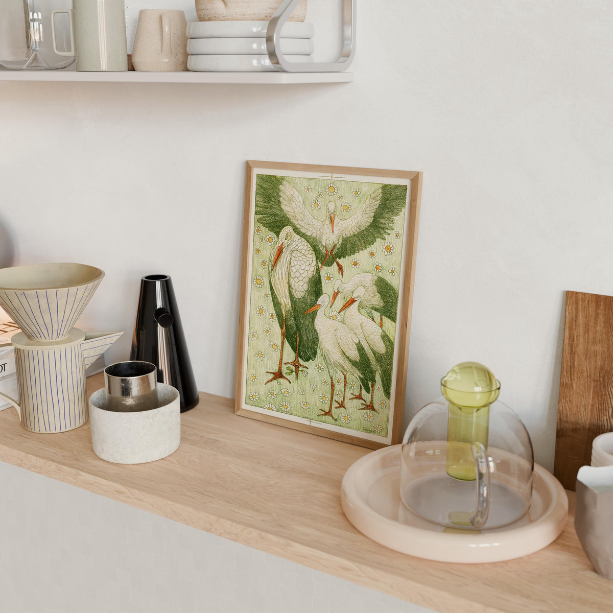 a wooden shelf with various items, including a framed illustration of three storks, a glass dome, and other decorative objects.