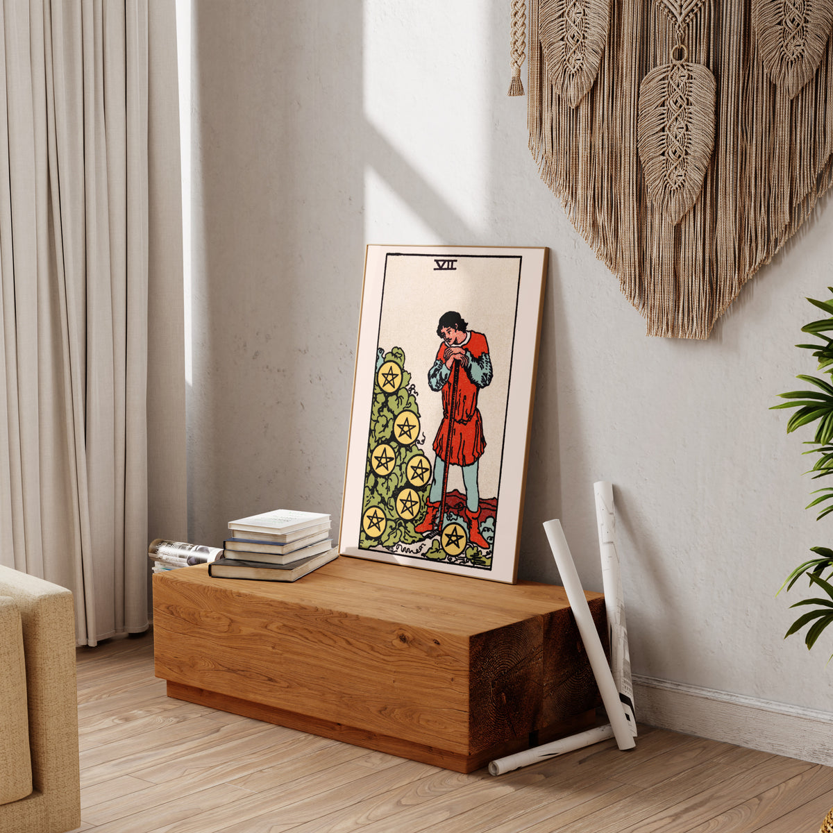 a wooden table with a framed tarot card on it, along with some books and a plant.