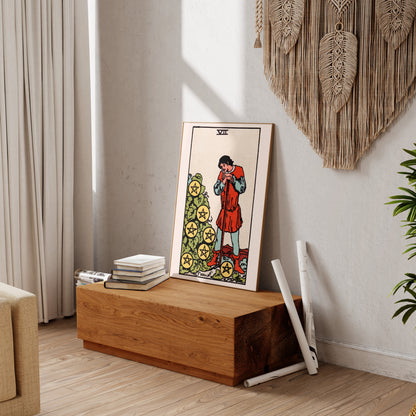 a wooden table with a framed tarot card on it, along with some books and a plant.