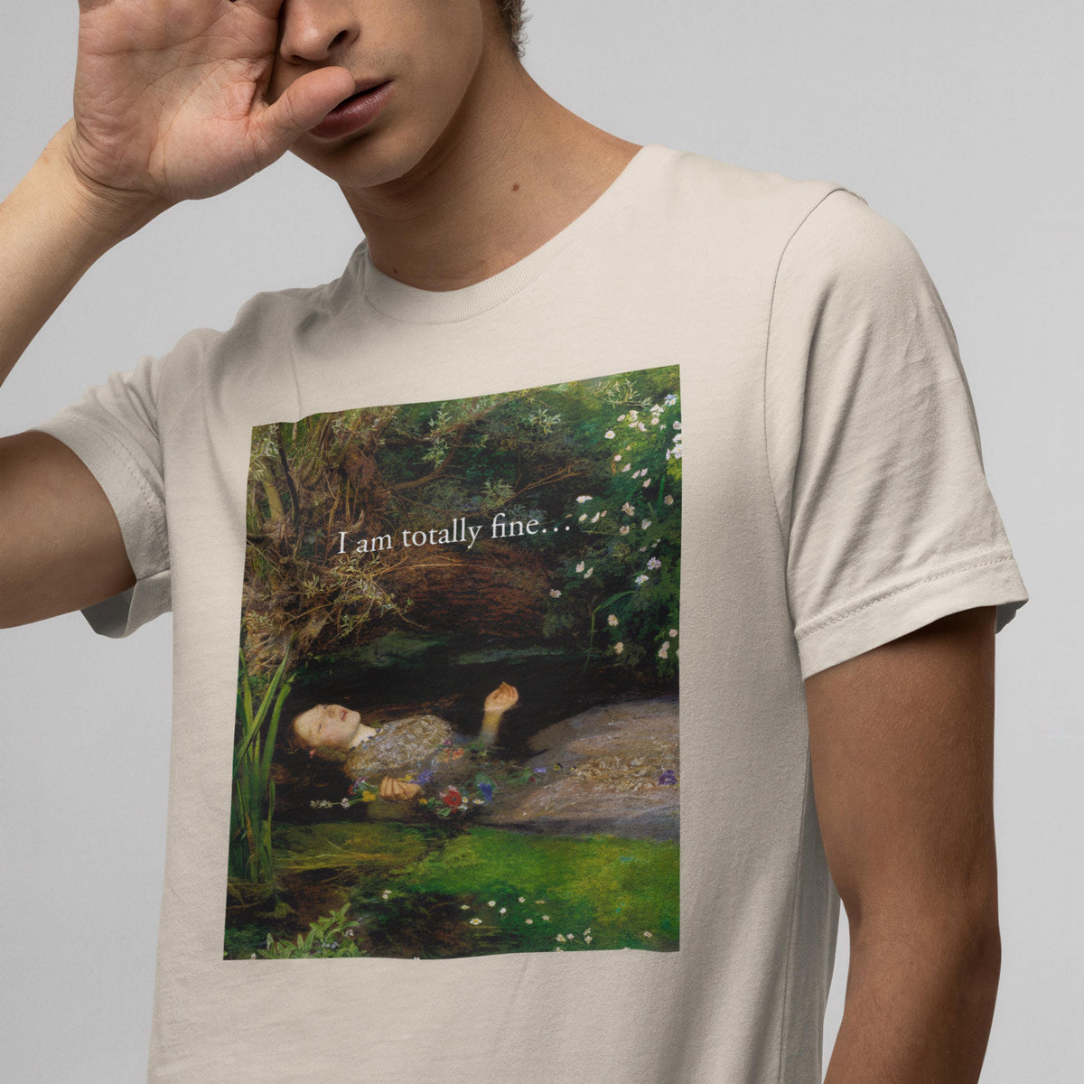 A person wearing a t-shirt with a printed image of a woman lying in a field with flowers.