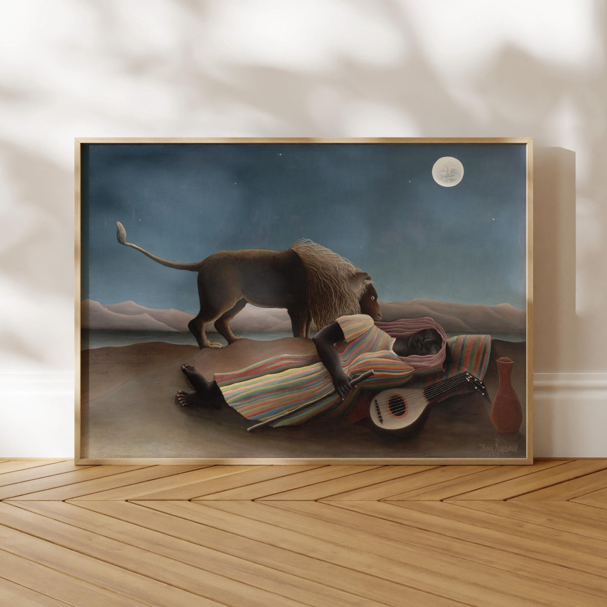 The image is a framed painting depicting a lion standing over a person lying on the ground, with a guitar nearby.