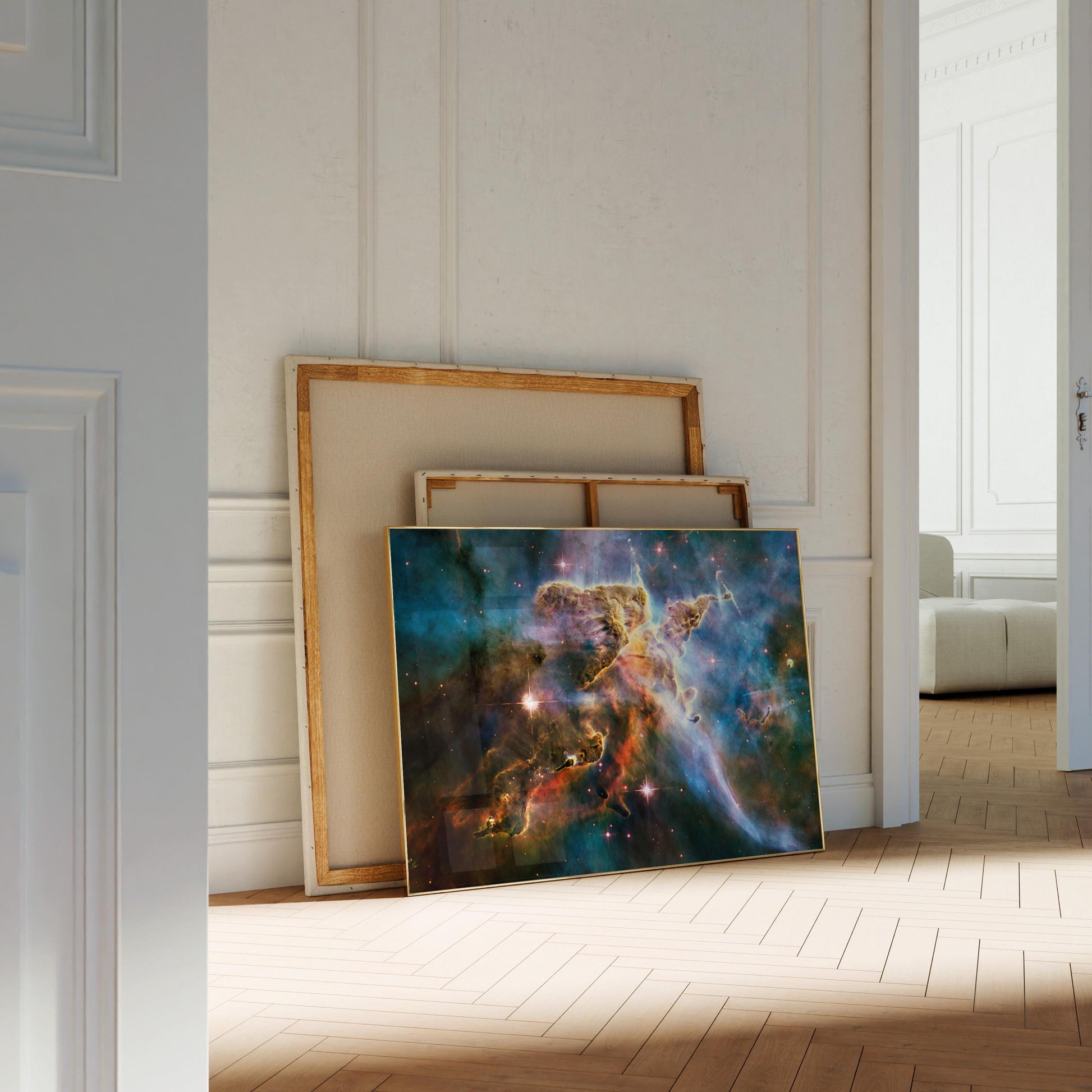 a large, colorful painting of a nebula, which is a vast cloud of gas and dust in outer space. The painting is displayed on a wooden floor in a room with white walls.