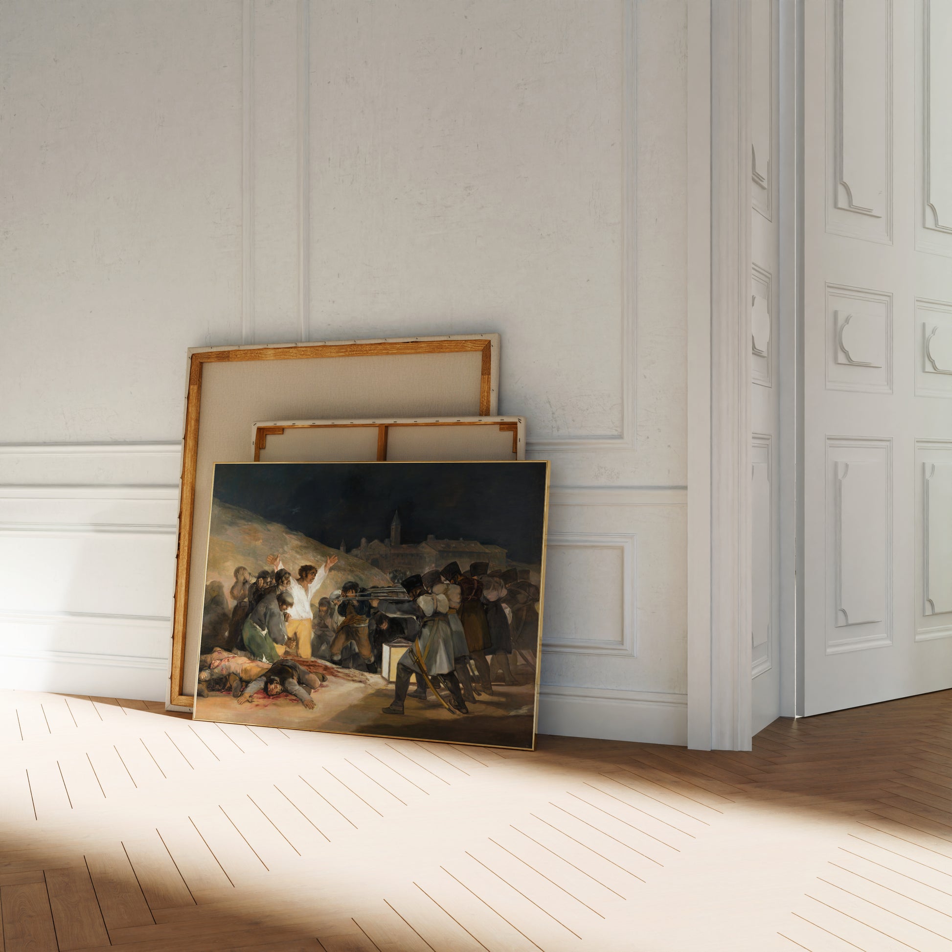 a painting of a group of people gathered around a fire, with some individuals holding what appears to be a pitcher. The painting is displayed on a white wall, and there are two other paintings stacked on top of it.