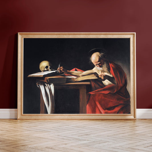 The image is a framed painting depicting a man sitting at a desk, writing on a book while a skull is visible on the desk.