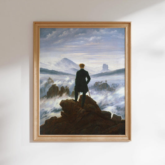 The image is a framed painting depicting a man standing on a rocky outcrop, gazing out at a misty, mountainous landscape.