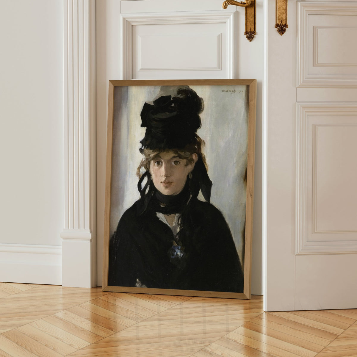 a framed portrait of a woman wearing a black hat, standing in a doorway.