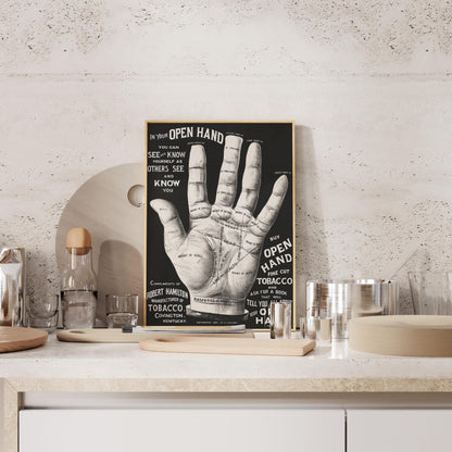 a poster of a hand with various texts and diagrams, displayed on a shelf or counter.